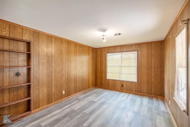 415 Sweetwater Rd, Bronte, TX 76933 - spare room featuring wooden walls, baseboards, a wealth of natural light, and wood finished floors