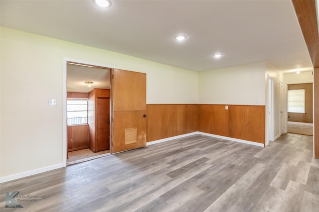 415 Sweetwater Rd, Bronte, TX 76933 - empty room with visible vents, wood walls, a wainscoted wall, and light wood-type flooring