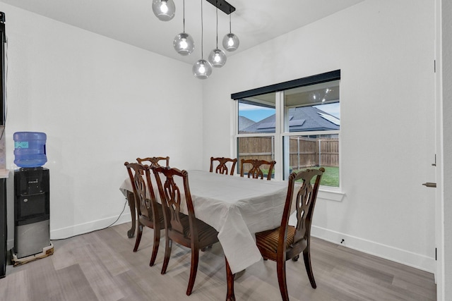 dining room with baseboards and light wood finished floors