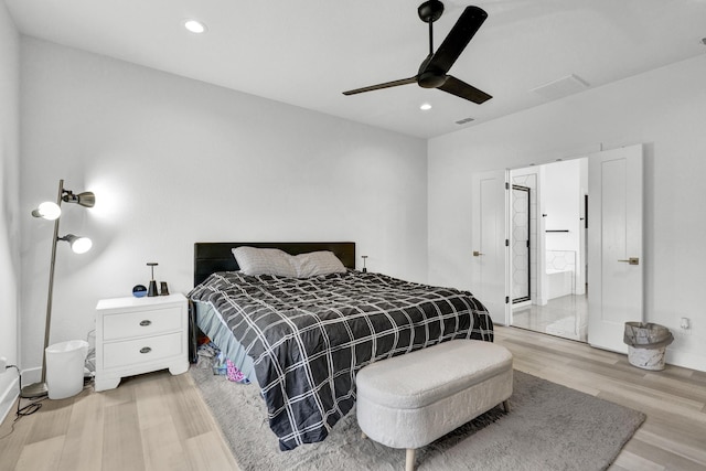 bedroom featuring baseboards, light wood-type flooring, recessed lighting, a ceiling fan, and ensuite bath