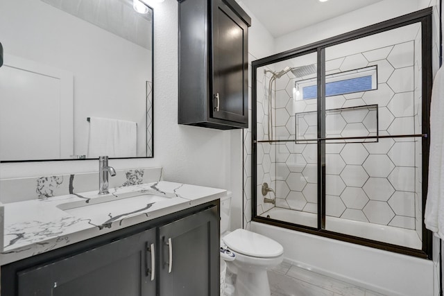 full bath featuring vanity, enclosed tub / shower combo, and toilet