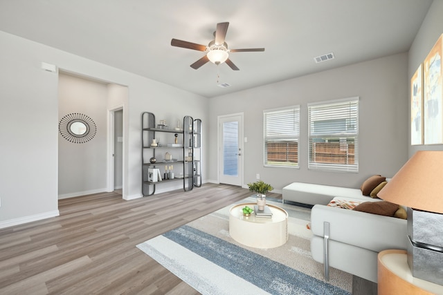 living room with baseboards, ceiling fan, visible vents, and wood finished floors