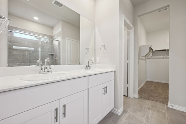 full bath featuring visible vents, a sink, a stall shower, and double vanity