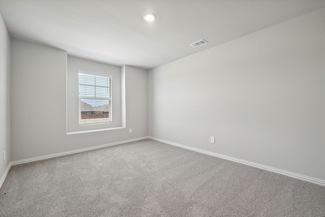 empty room with visible vents, carpet, and baseboards