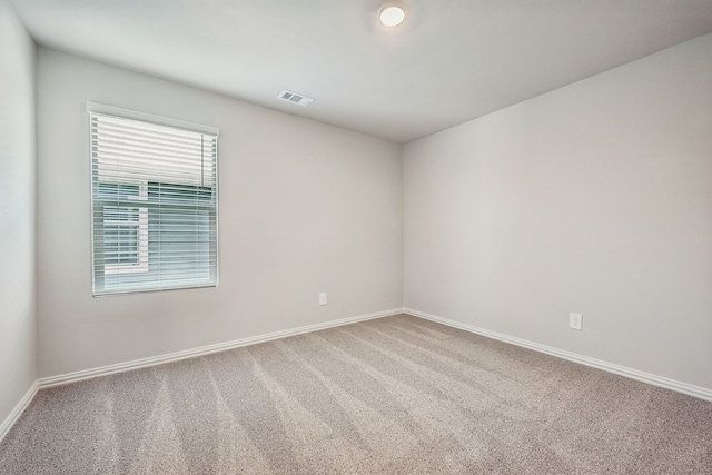 empty room with visible vents, baseboards, and carpet floors