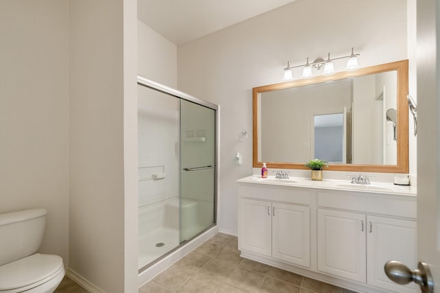 bathroom featuring toilet, tile patterned floors, a shower stall, and a sink