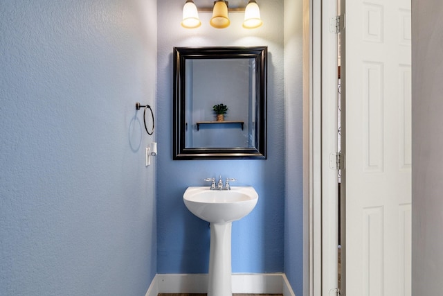 bathroom with baseboards and a textured wall