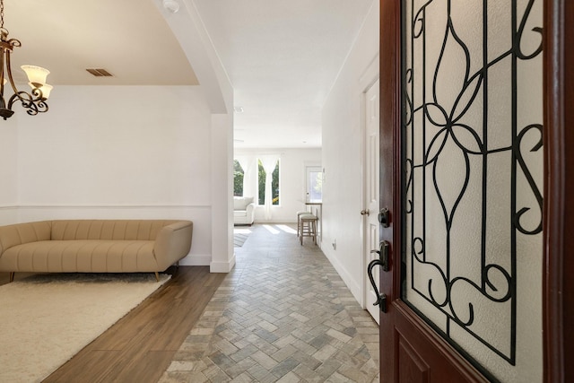 entrance foyer featuring visible vents, baseboards, and an inviting chandelier