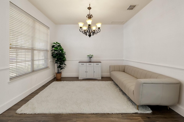 living area featuring a notable chandelier, dark wood finished floors, and visible vents