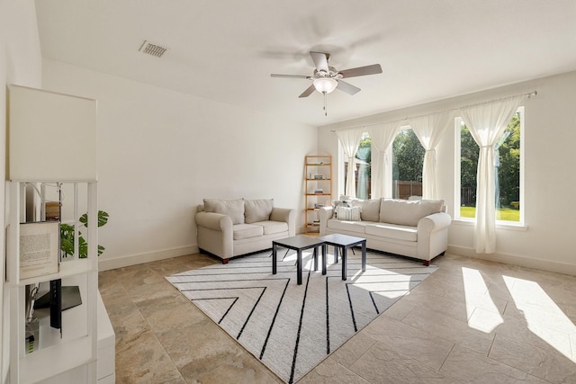 living room featuring baseboards, a ceiling fan, and visible vents