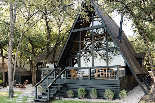 view of front of home featuring an outdoor structure, a deck, stairway, and a shed