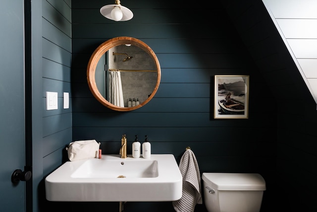 bathroom with toilet, a shower with curtain, and a sink