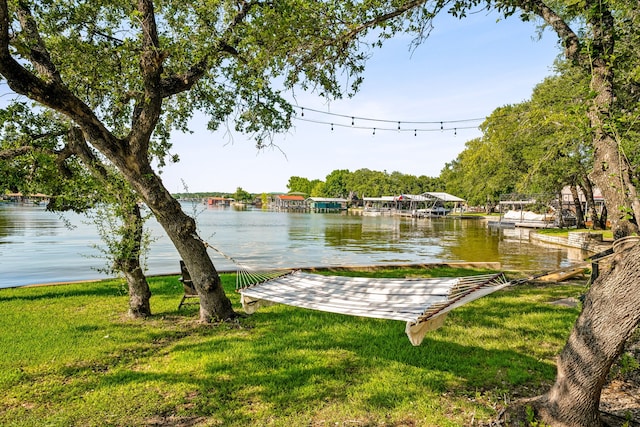 view of dock featuring a water view and a yard