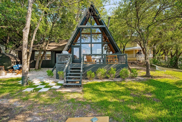 rear view of property featuring a lawn