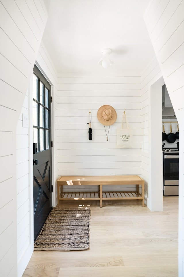 mudroom with wood walls and wood finished floors