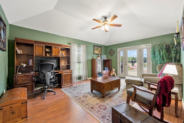 home office with french doors, a ceiling fan, vaulted ceiling, and wood finished floors