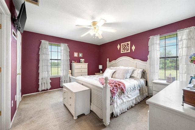 bedroom featuring a ceiling fan, light colored carpet, and visible vents