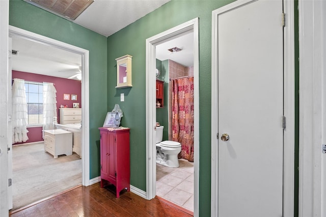 hallway featuring wood finished floors and visible vents