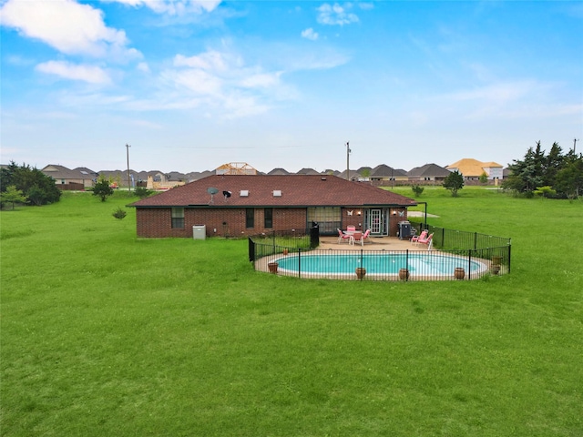view of swimming pool featuring fence, a residential view, a fenced in pool, a patio area, and a yard