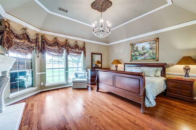 bedroom with crown molding, wood finished floors, a chandelier, and visible vents