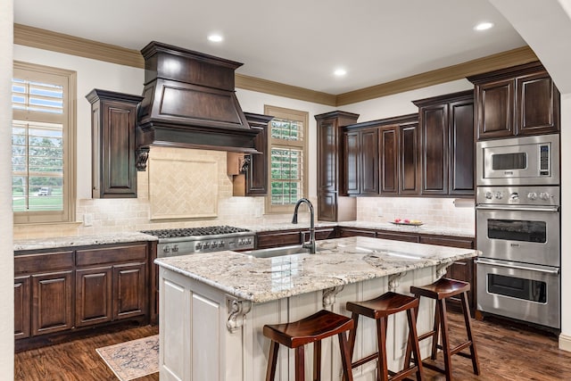 11374 Texas Highway 154 S, Yantis, TX 75497 - kitchen with dark brown cabinets, appliances with stainless steel finishes, a center island with sink, and a sink