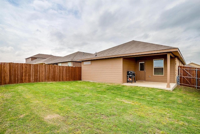 rear view of house with a fenced backyard, a lawn, and a patio area