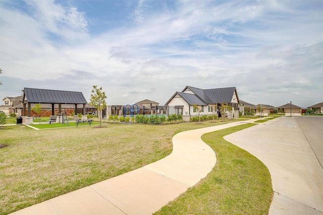 surrounding community with fence, a yard, and a residential view