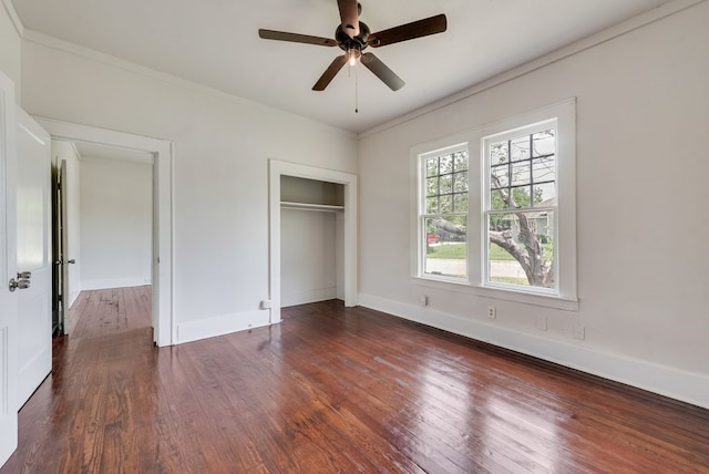 unfurnished bedroom featuring a closet, baseboards, ornamental molding, and dark wood-type flooring