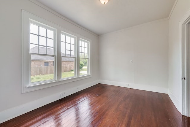 unfurnished room featuring baseboards, ornamental molding, and dark wood finished floors