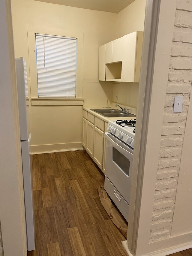 kitchen featuring white appliances, white cabinetry, dark wood-style floors, and a sink