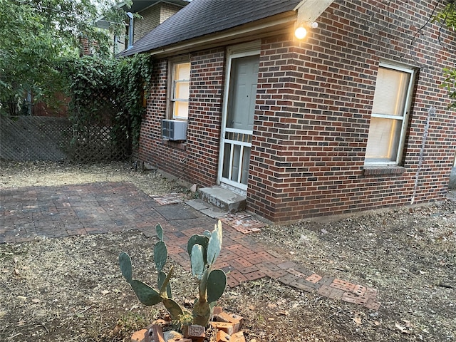 1811 8th St, Wichita Falls, TX 76301 - view of side of home with cooling unit, brick siding, entry steps, and a patio area