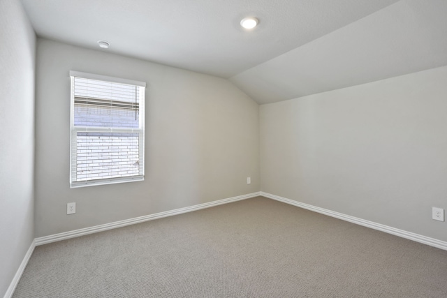 additional living space with carpet floors, baseboards, a wealth of natural light, and lofted ceiling