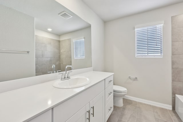 bathroom with vanity, toilet, a washtub, baseboards, and visible vents
