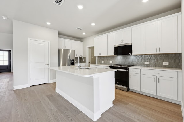 kitchen featuring range with gas cooktop, visible vents, a sink, stainless steel fridge with ice dispenser, and light countertops
