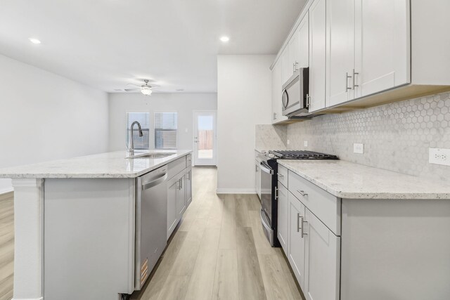607 Willet Dr, Mckinney, TX 75069 - kitchen with ceiling fan, appliances with stainless steel finishes, a sink, light wood-type flooring, and backsplash