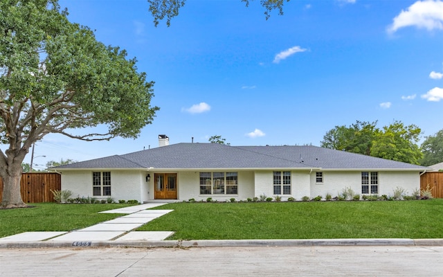 single story home with fence, a chimney, brick siding, and a front yard