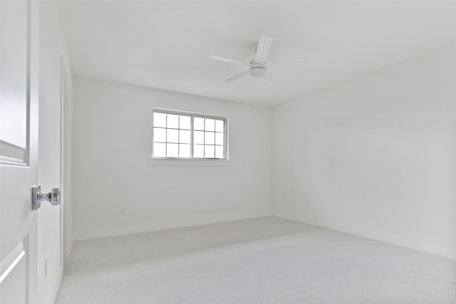 carpeted spare room featuring a ceiling fan