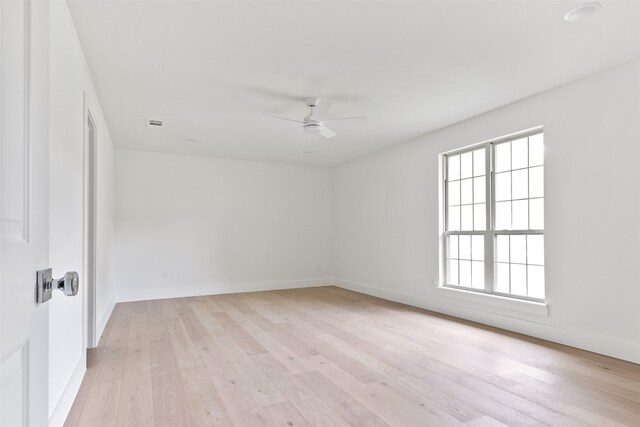 unfurnished room with a ceiling fan, baseboards, and light wood-style floors