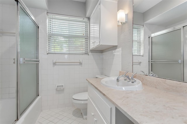 6007 Sandhurst Ln Unit B, Dallas, TX 75206 - full bathroom with vanity, toilet, tile walls, bath / shower combo with glass door, and tile patterned floors