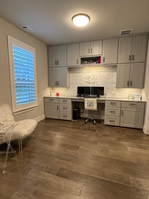 kitchen with built in study area, backsplash, visible vents, and gray cabinetry