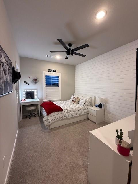 carpeted bedroom featuring baseboards, a ceiling fan, and visible vents
