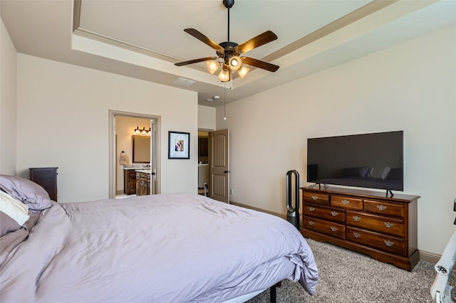 carpeted bedroom featuring a raised ceiling, ensuite bathroom, ceiling fan, and visible vents