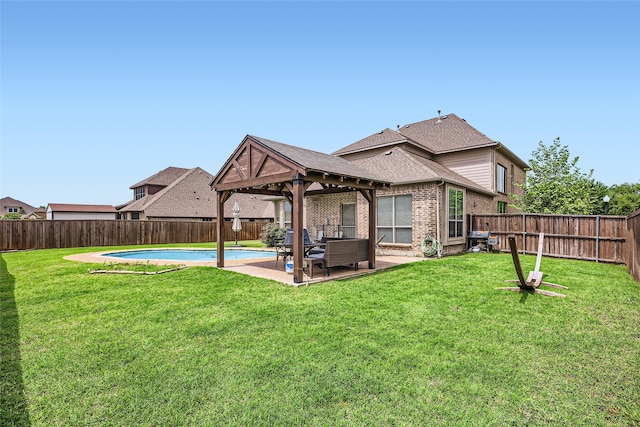 rear view of property with a fenced backyard, a yard, a patio area, and brick siding