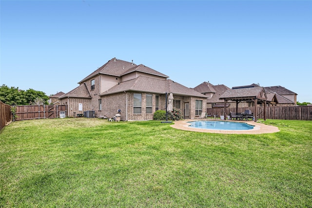 exterior space with a fenced backyard, cooling unit, a yard, and brick siding
