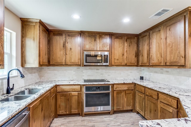 140 Tnt Ct, Springtown, TX 76082 - kitchen featuring brown cabinetry, a sink, and stainless steel appliances