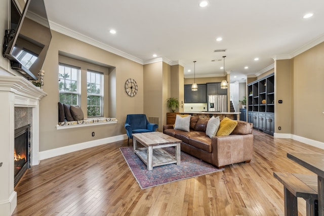 5102 Ridgedale Ave, Dallas, TX 75206 - living room with light wood finished floors, a glass covered fireplace, ornamental molding, recessed lighting, and baseboards