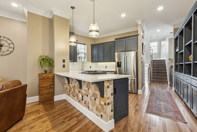 5102 Ridgedale Ave, Dallas, TX 75206 - kitchen with appliances with stainless steel finishes, crown molding, a peninsula, backsplash, and light countertops