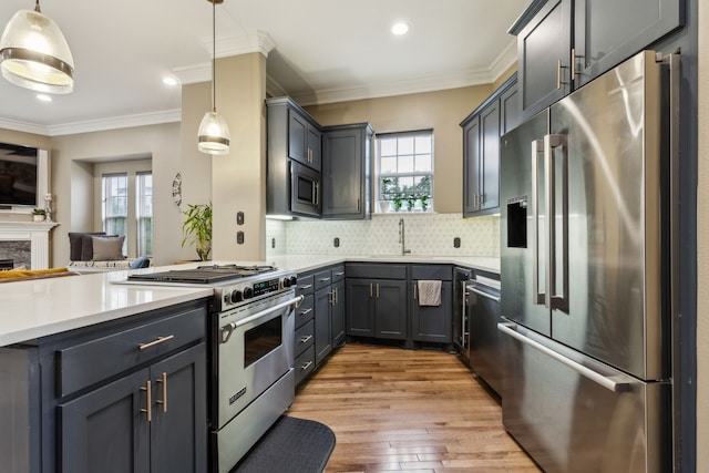 5102 Ridgedale Ave, Dallas, TX 75206 - kitchen with premium appliances, a sink, decorative backsplash, light countertops, and light wood-style floors