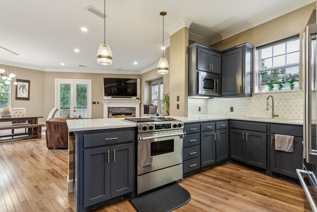 5102 Ridgedale Ave, Dallas, TX 75206 - kitchen featuring stainless steel appliances, a sink, a peninsula, plenty of natural light, and ornamental molding