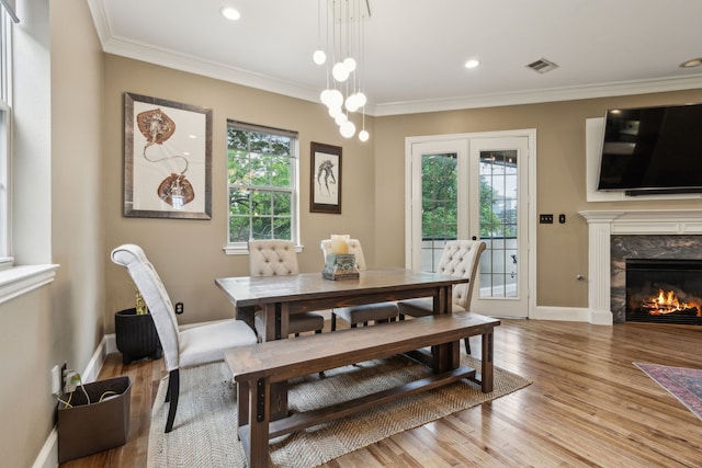 5102 Ridgedale Ave, Dallas, TX 75206 - dining space featuring plenty of natural light, light wood-style flooring, crown molding, a high end fireplace, and baseboards